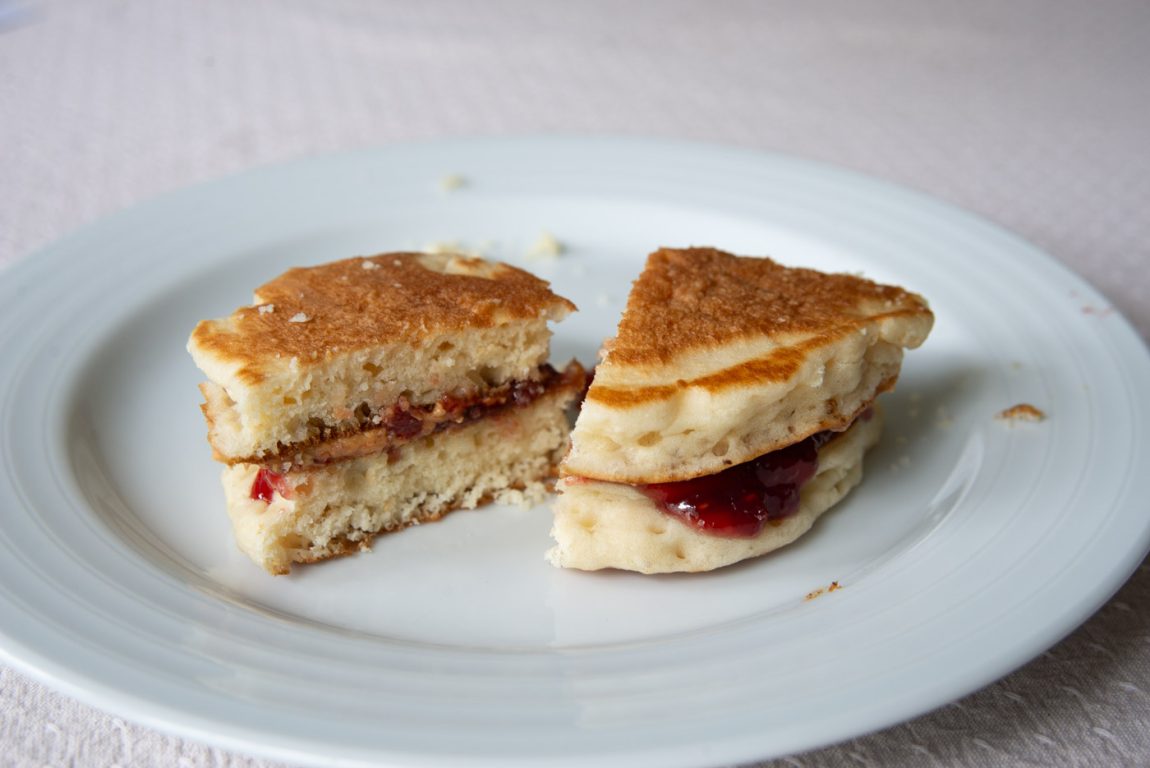Photo of PB&J sandwich at home, using leftover pancakes. The jelly and peanut butter are spread on thick.