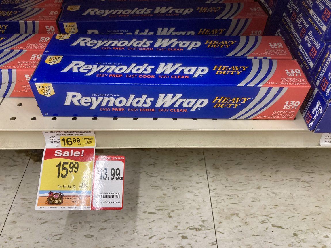 Reynolds Wrap on the bottom shelf of a suburban grocery store in Glen Ellyn, IL. The cost is 16.99 for 130 square feet. A sale tag says it's $15.99. And addtional sales tag says it's $13.99 with digital coupon.