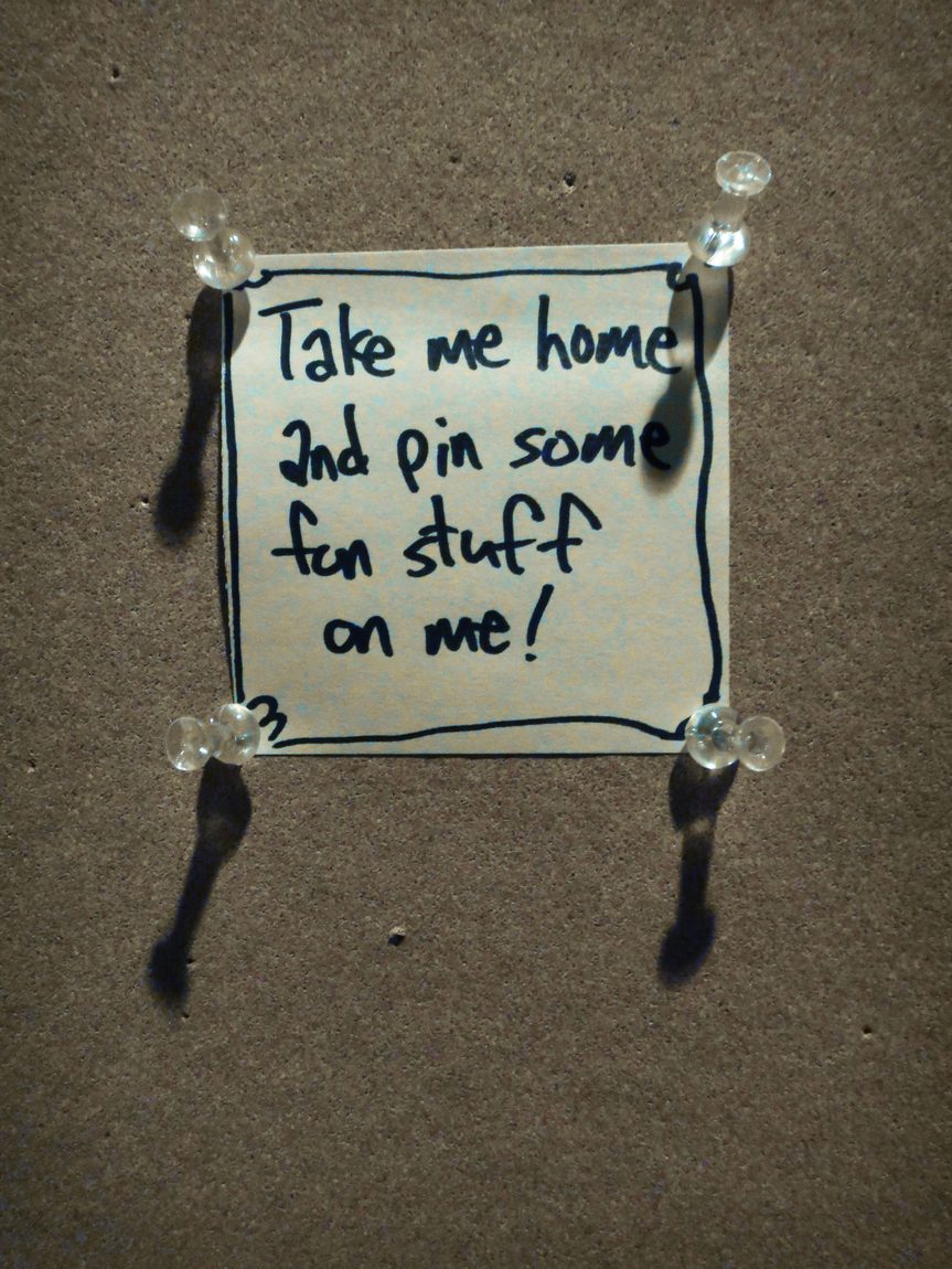 Bulletin board left in alley. The note says, "Take me home and pin some fun stuff on me!"