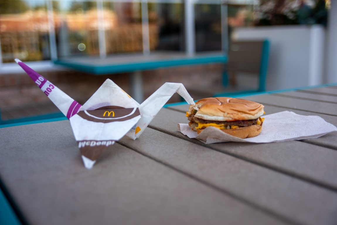 Origami crane made from McDouble wrapper eats a McDouble