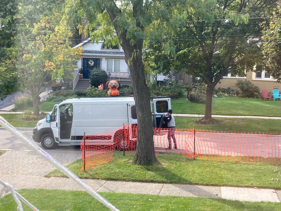 Metal shelves being loaded into white van. The man really had to push the shelves to make them fit into the van. 